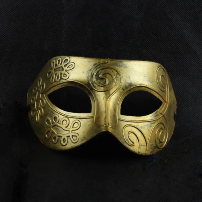 Gold mask with intricate designs on a black background